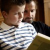 Father and son reading a book together.